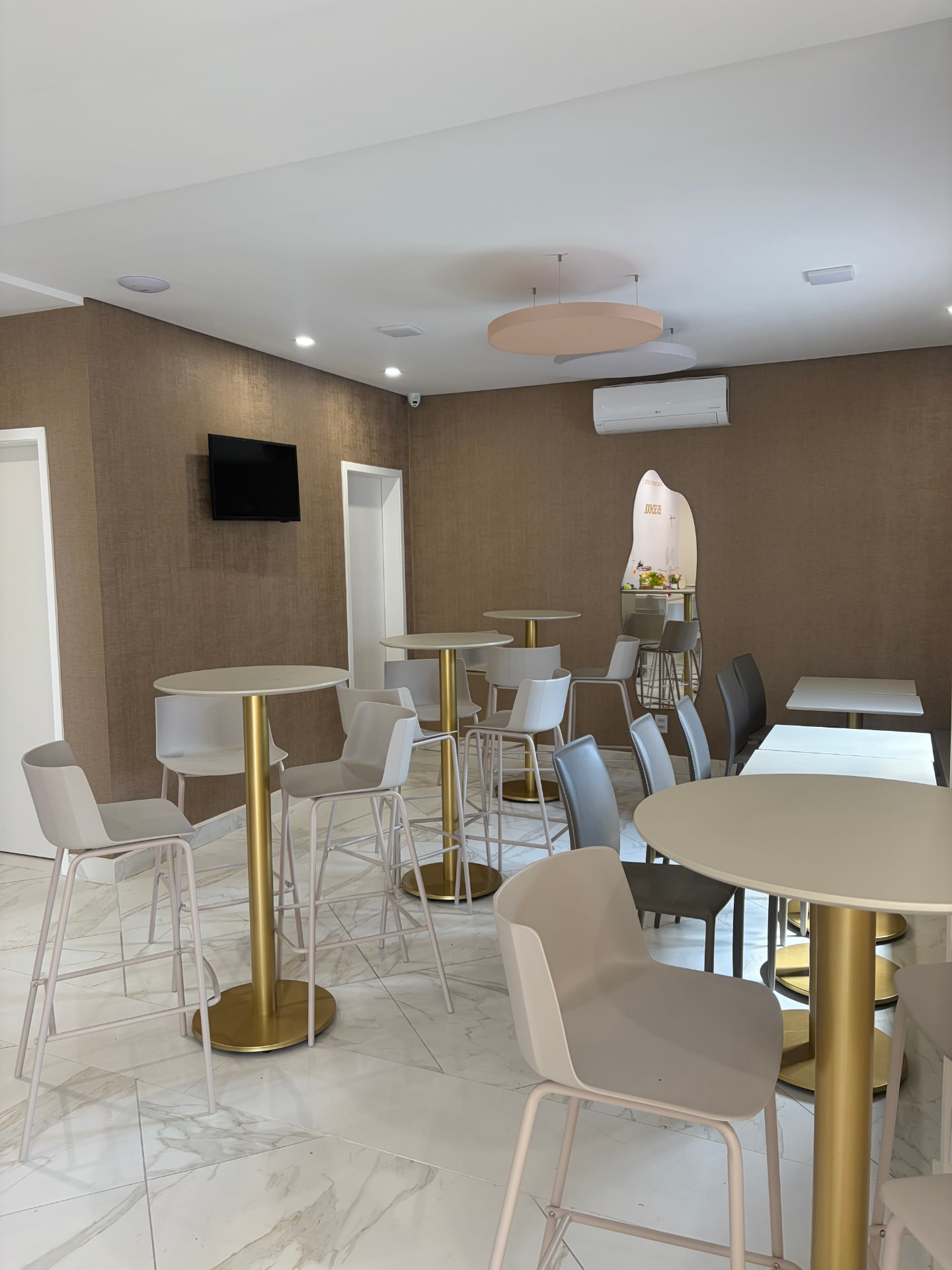 Área de apoio com mesas altas e lounge